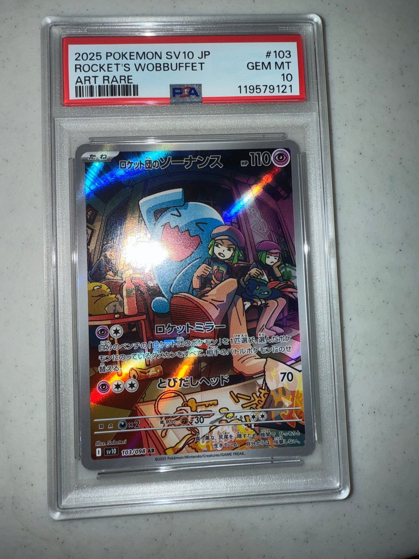 irl front of 2025 POKEMON JAPANESE SV10-GLORY OF TEAM ROCKET #103 ROCKET'S WOBBUFFET ART RARE PSA 10